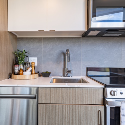 Cozy kitchen with white cabinetry inside Pinnacle Apartments