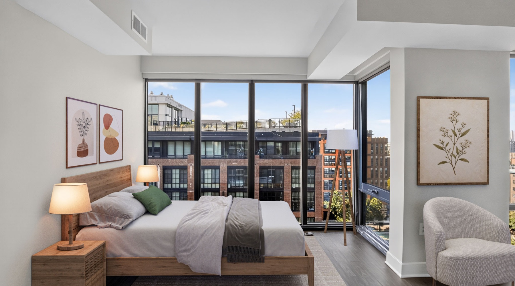 Bright studio apartment with floor-to-ceiling corner windows, wood flooring, modern furnishings, and city views.