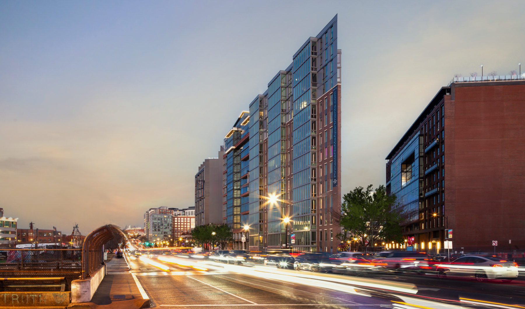 evening view of exterior of building with cars driving by