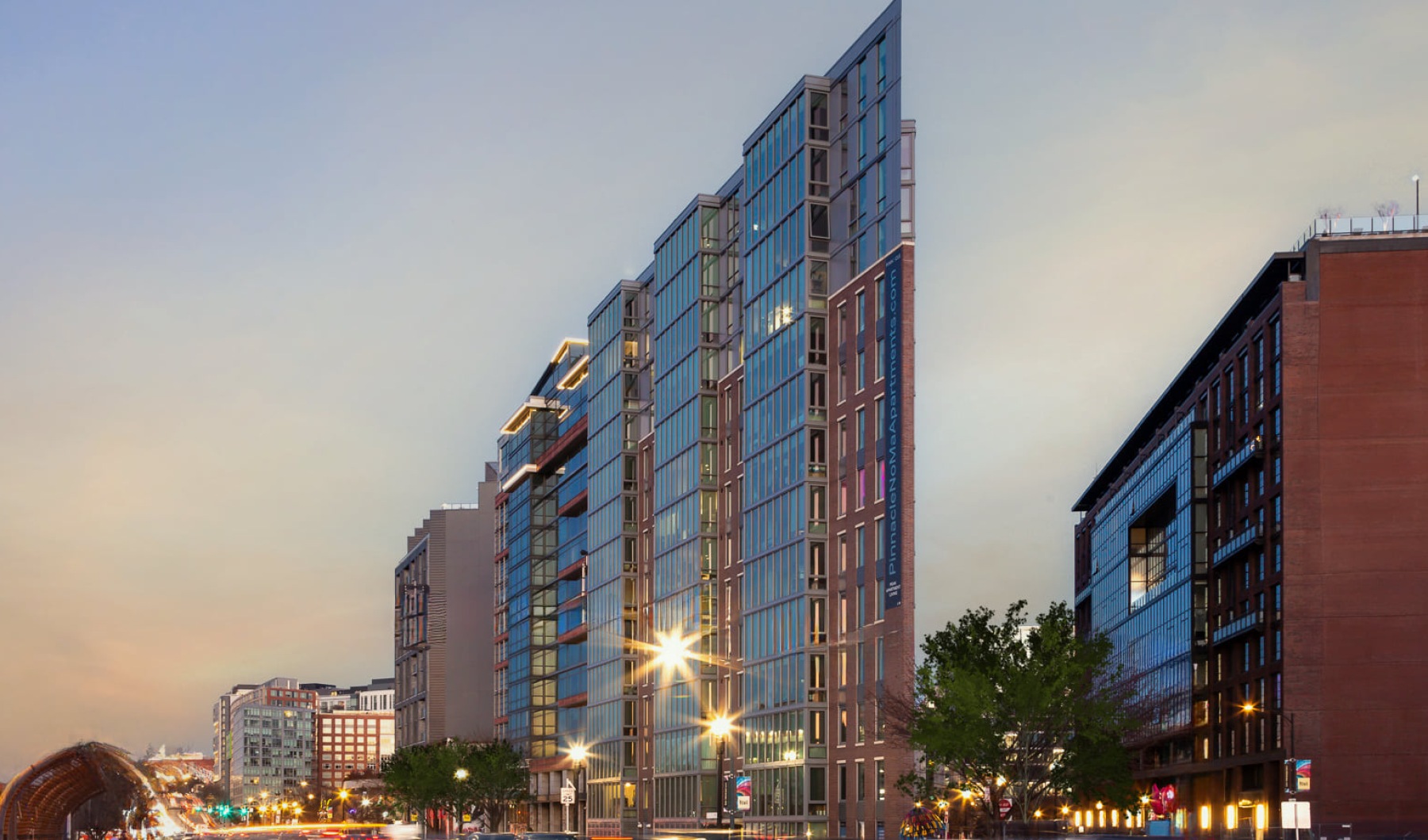 evening view of exterior of building with cars driving by