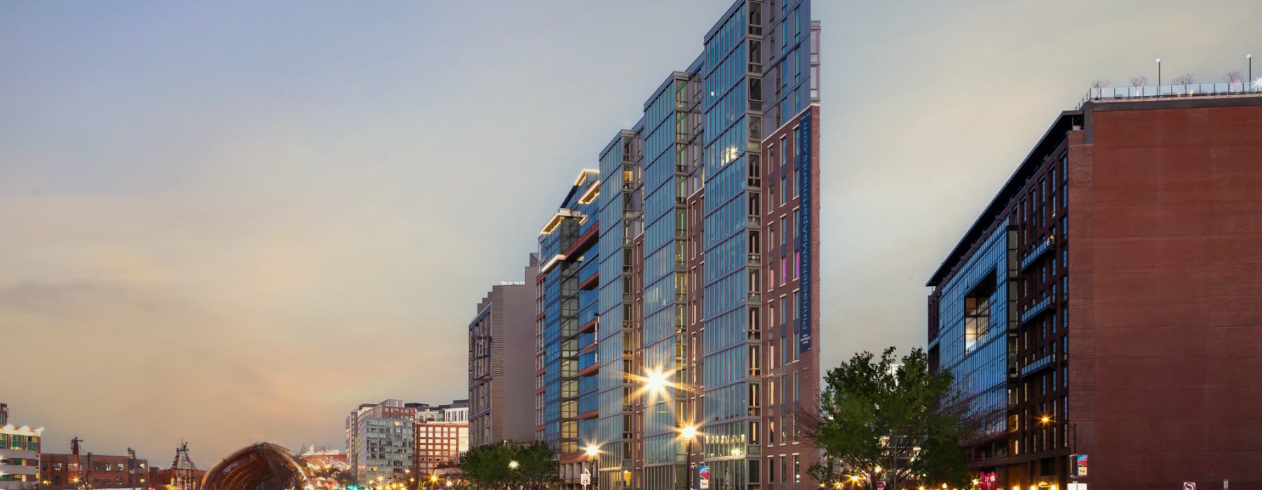 evening view of exterior of building with cars driving by