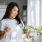 A woman holding a plant in a sunny window in Pinnacle Apartments