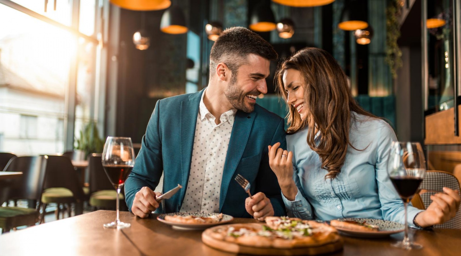 A man and woman eating pizza in NoMa local restaurant 